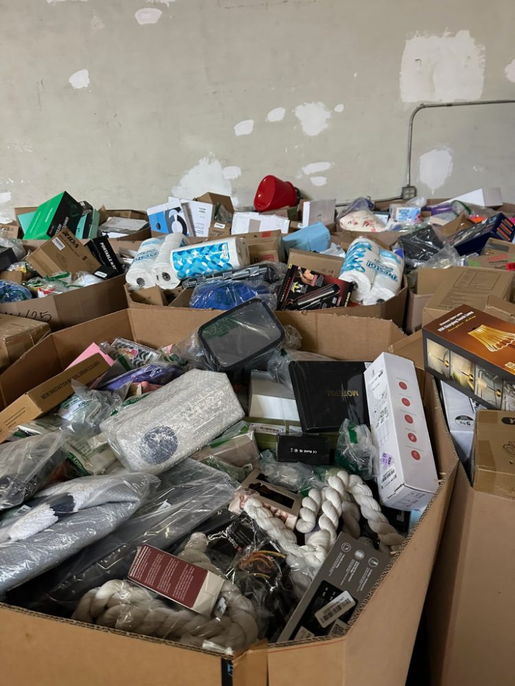 Gaylords con artículos de hogar, papel y accesorios revueltos en el almacén de origen